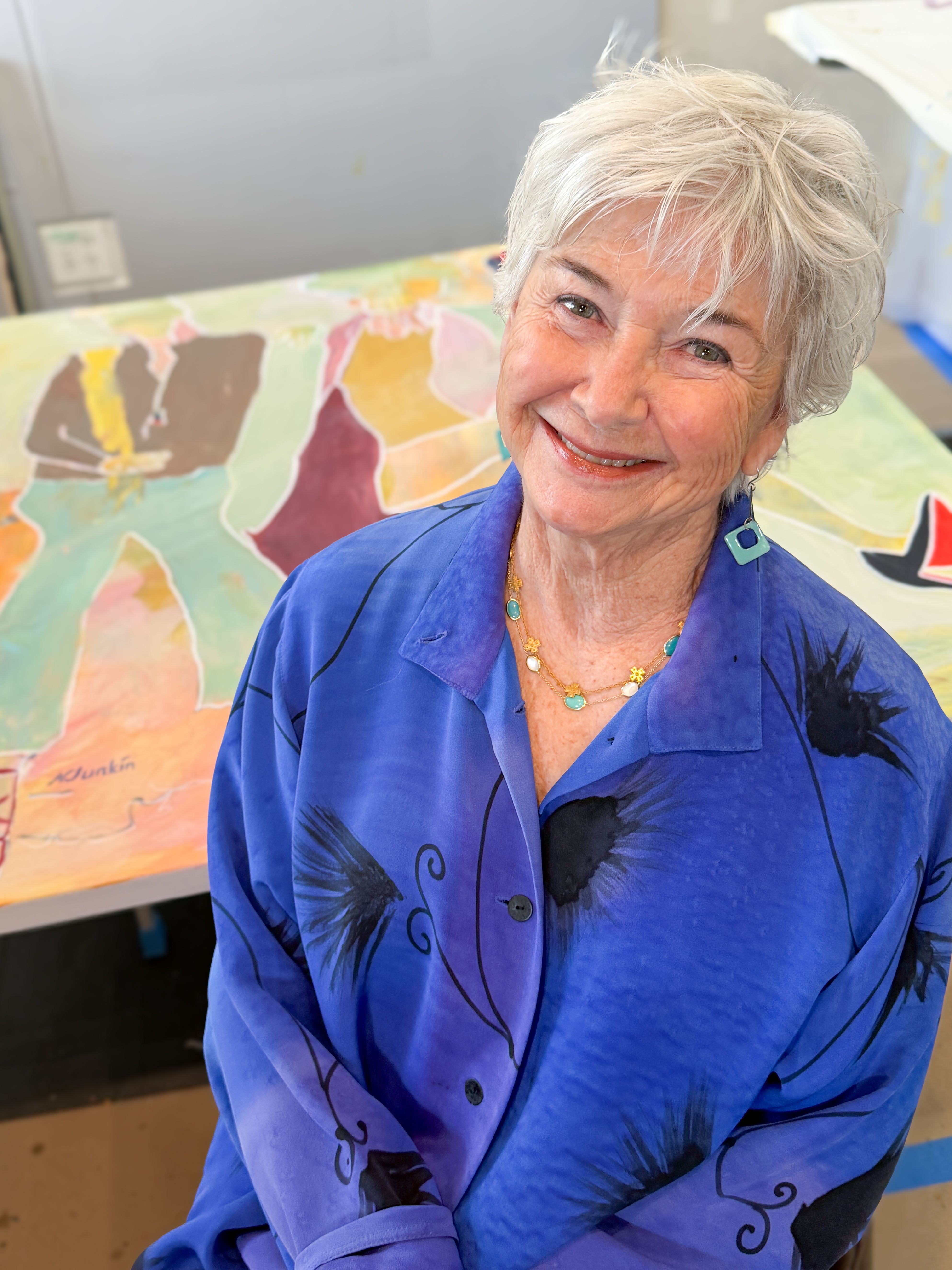 Nancy Junkin in her studio beside a colorful abstract painting